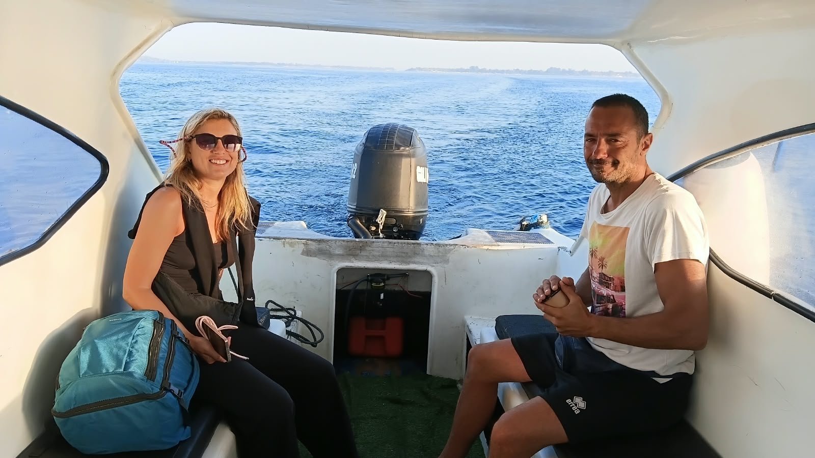 Guests seated near the outboard engine on a private charter